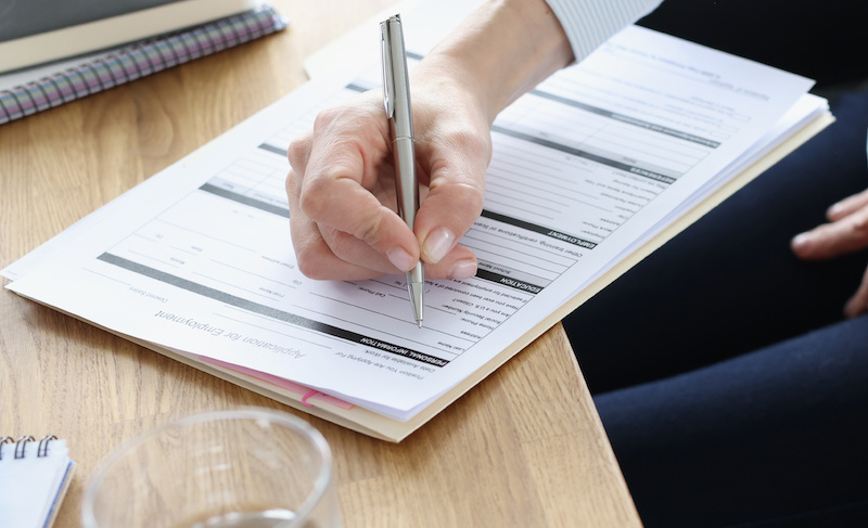 hand holdiing a pen to fill out a form